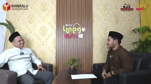 Ayon Diniyanto (narasumber) dan Sholawat Takbir Jagad Lanang (host) sedang melakukan podcast, dengan posisi narasumber di sebelah kiri dan host di sebelah kanan dari sudut pandang layar.